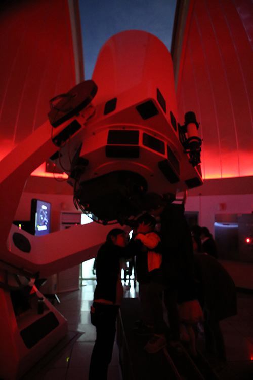 A member of staff from Gwacheon National Science Museum helping a child to use the telescope to observe star at the last “Moon and Star Open Observation Event.”